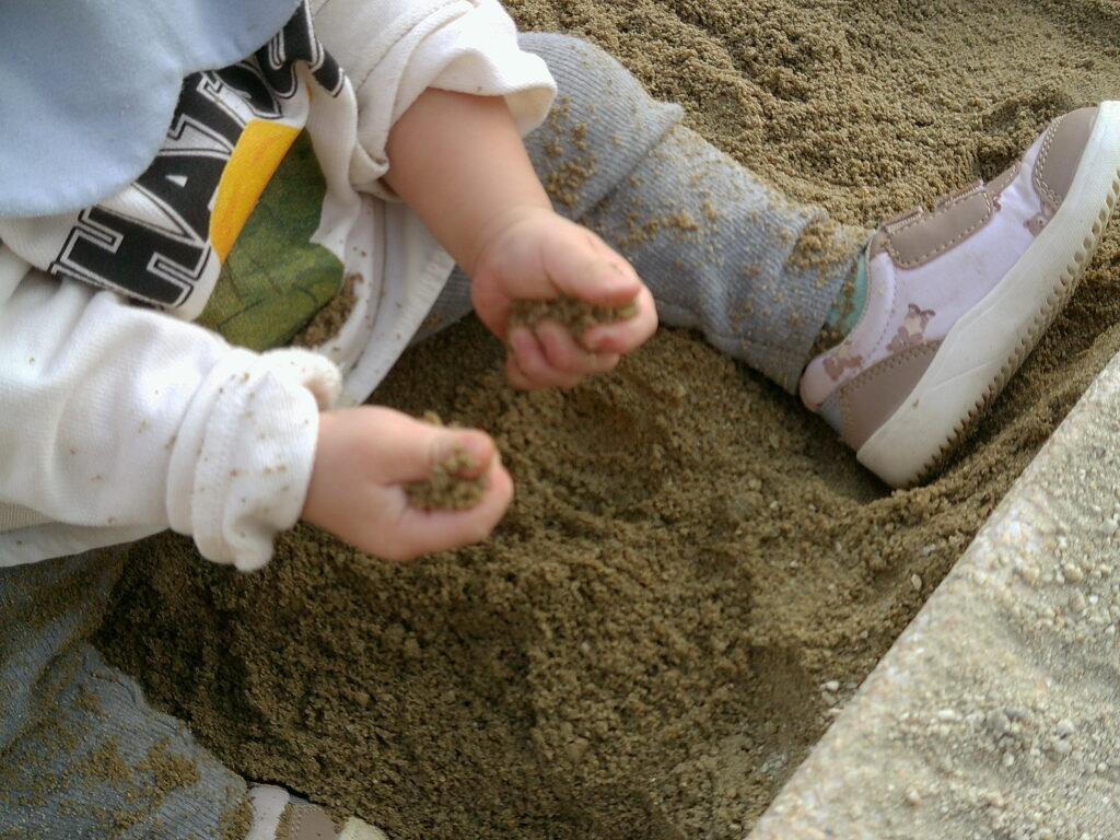 赤ちゃんが砂場で遊ぶ姿