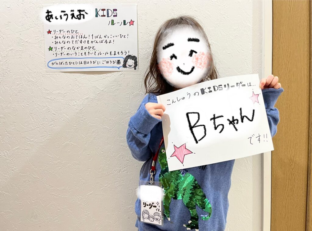 女の子がパネルを持って笑っている写真
