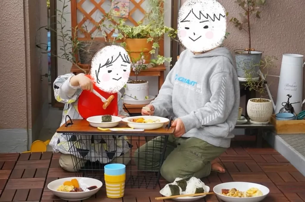 バルコニーで子供たちがご飯を食べる様子