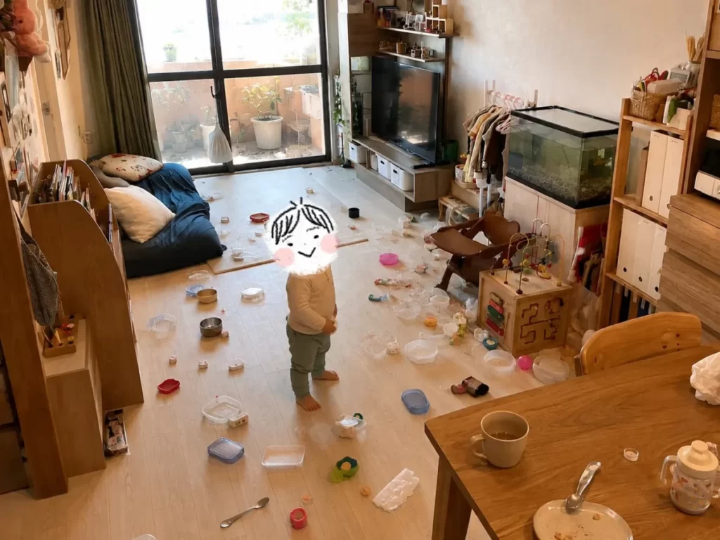 散らかしたリビングでにんまりする1歳の次男