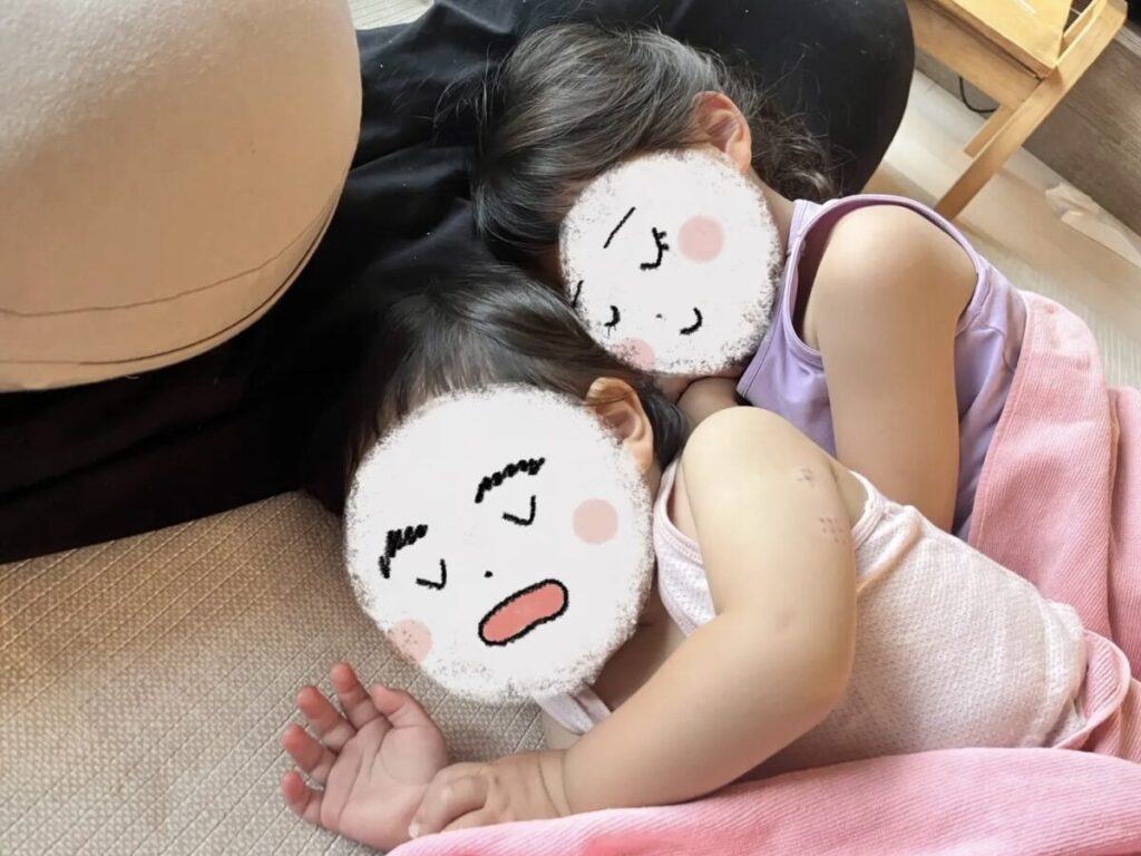 リビングのカーペットの上で子どもたちが寝ている様子