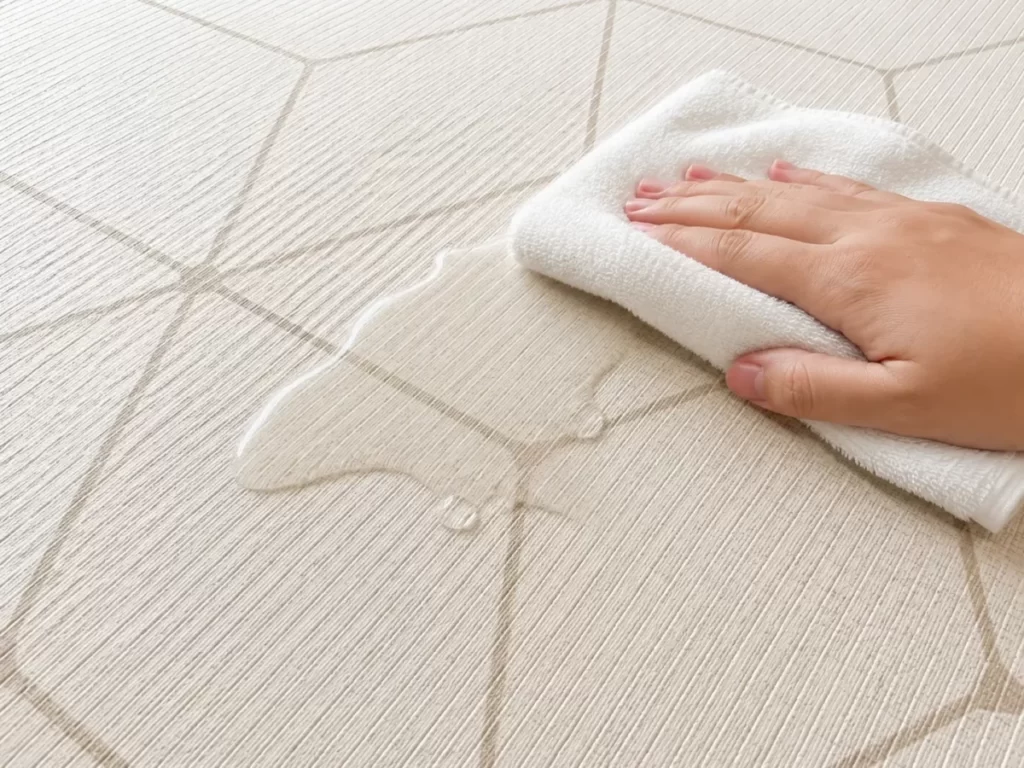 カーペットにこぼれた水を拭く様子