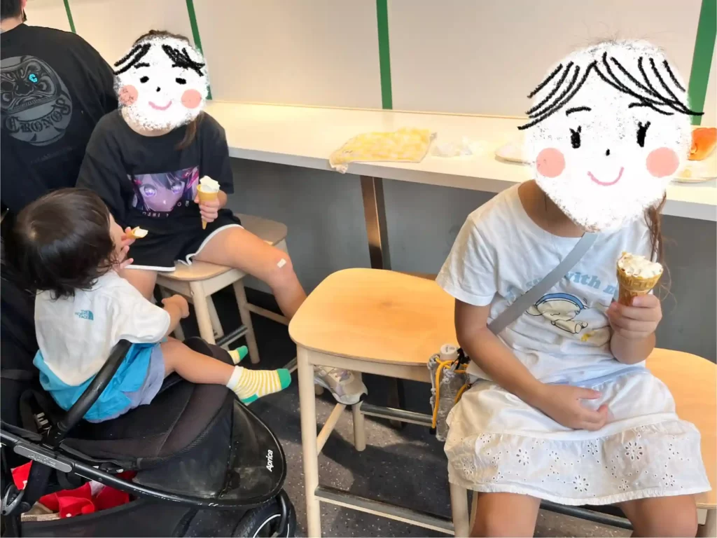 ソフトクリームとホットドックを食べる子どもたち